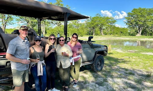 A group of tourists posing with safari vehicle, Botswana